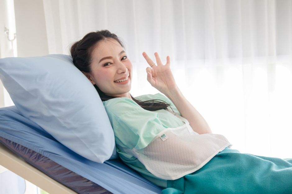 A smiling female patient showing ok sign
